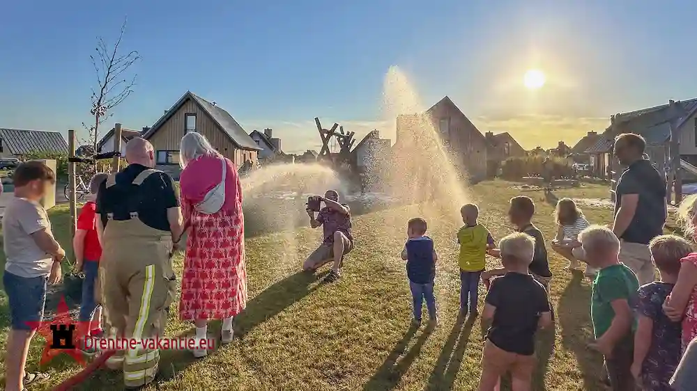 Kinderen mogen met de brandweer slang spuiten.